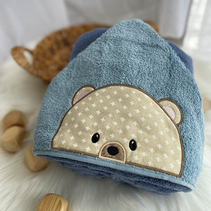 Blue towel with bear face design on a white surface