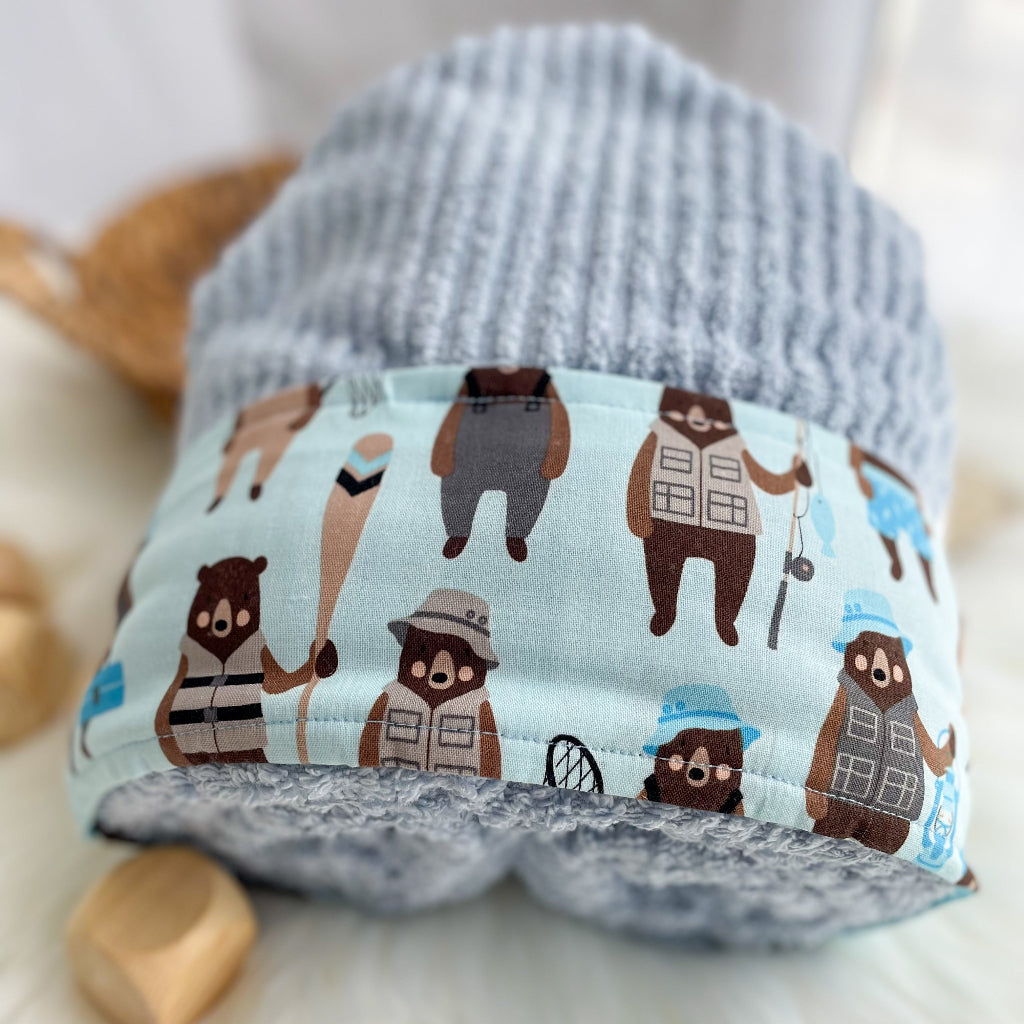 Kids hooded towel with a camping bear pattern on a light background