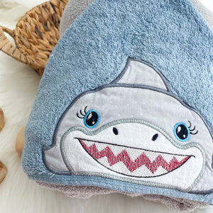 Children's towel with shark design on a light wooden surface