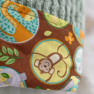 Close-up of fabric with monkey and giraffe pattern on brown background