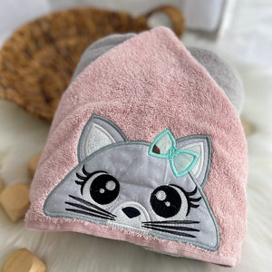 Pink towel with a cat face design on a light background