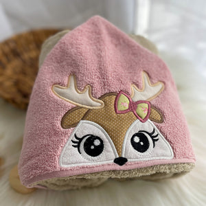 Pink towel with a deer face design on a soft surface