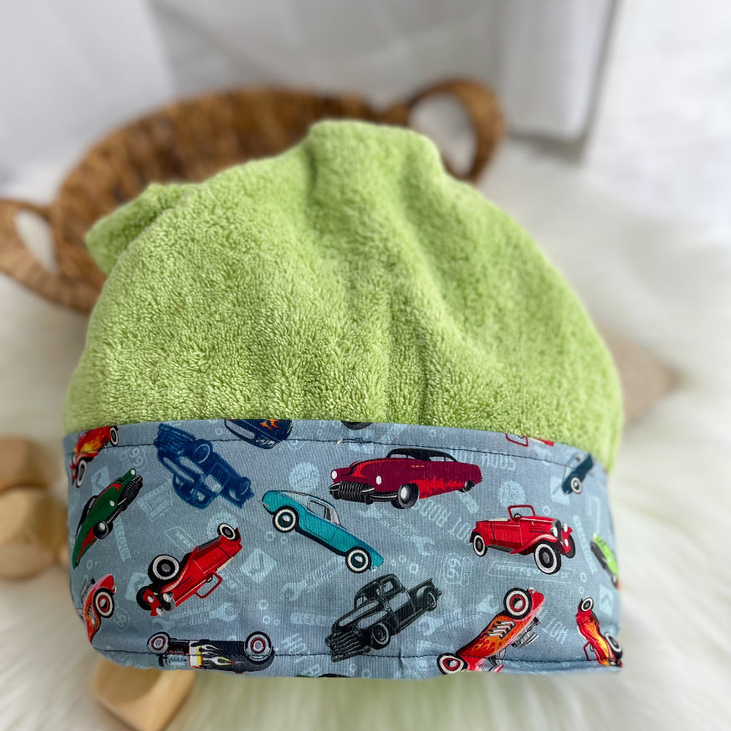 Lime green hooded towel folded with a fabric trim featuring classic cars