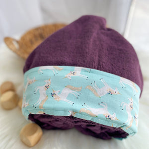 Purple hooded towel folded with unicorn fabric trim