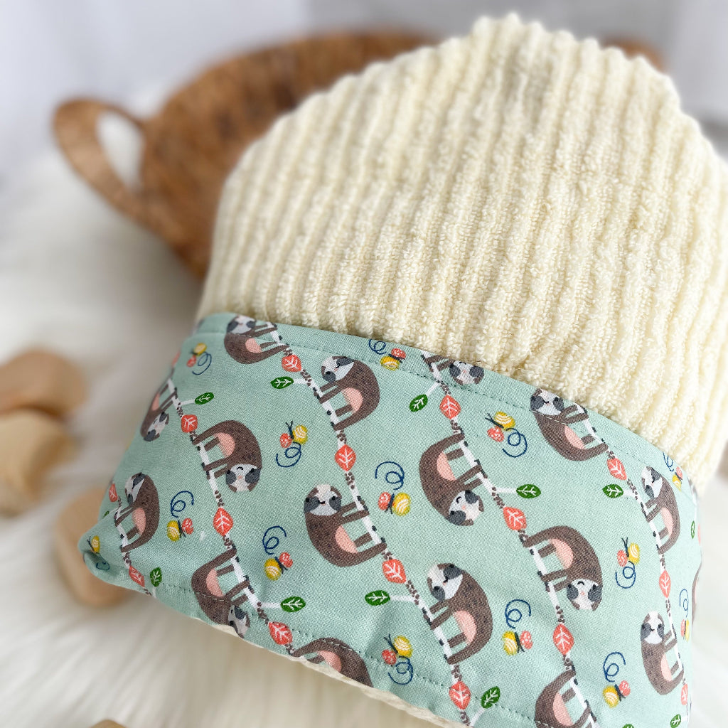 Yellow hooded towel with mint green fabric trim featuring sloths