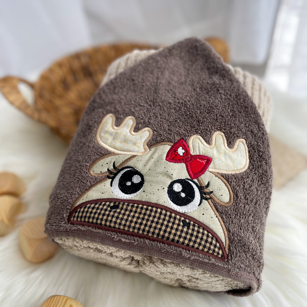 Children's hood with a cartoon moose design on a neutral background