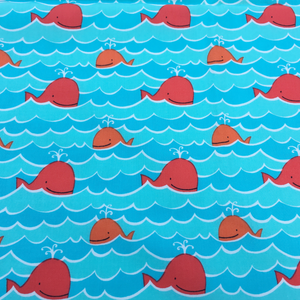 Blue fabric with orange whales on a background of waves