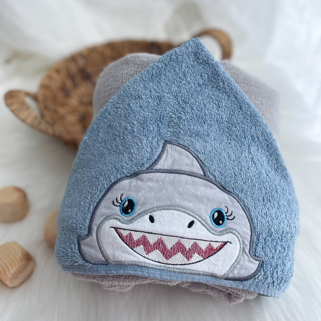 Shark appliqued face on a blue towel hood