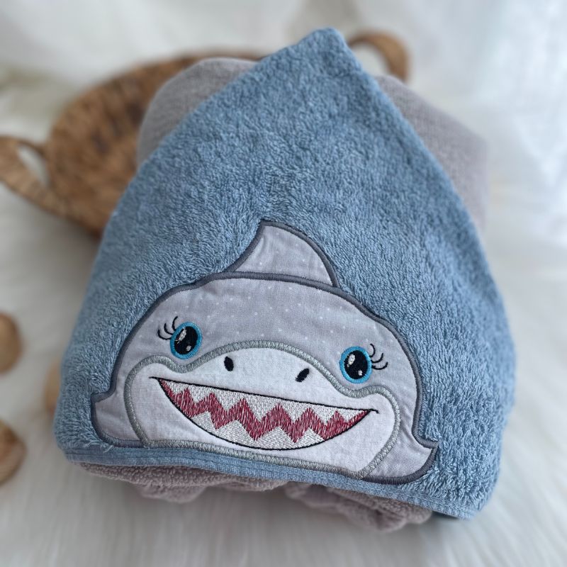Towel folded with a shark face on a blue background