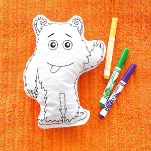 Silly Monster Coloring Doll & Party Favor laying on an orange towel with a yellow green and purple washable marker