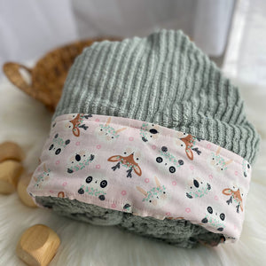 Woodland fabric on green ribbed texture and pink pattern with deer on a white surface.