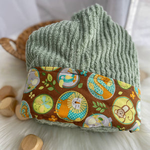 Green towel with a brown trim featuring safari animals