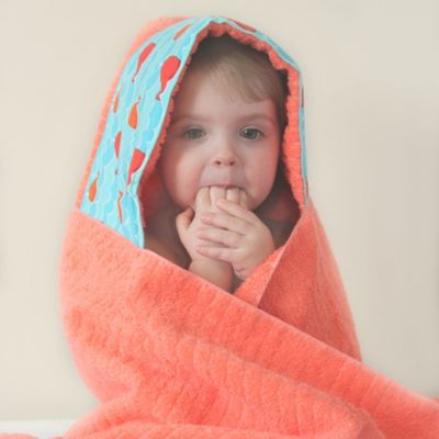 toddler in a hooded towel with whale fabric trim